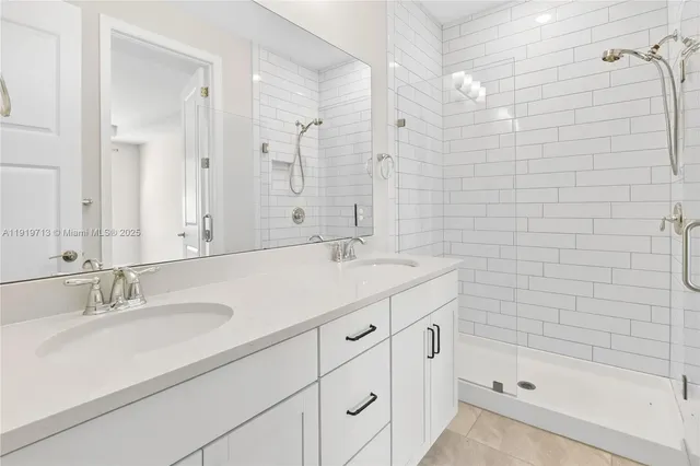 a bathroom with a sink double vanity granite tub shower and a mirror