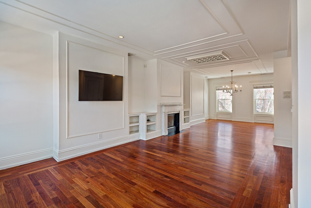 65 Rutland Street, Unit 3 Boston, MA 02118 - Photo 16 of 25 a view of empty room with wooden floor and fireplace