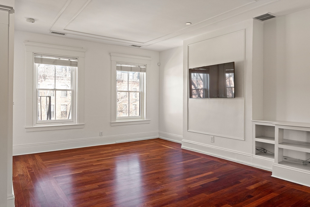65 Rutland Street, Unit 3 Boston, MA 02118 - Photo 17 of 25 an empty room with wooden floor and windows