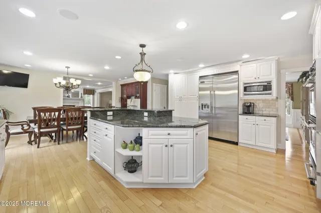a dining room with furniture a chandelier and wooden floor