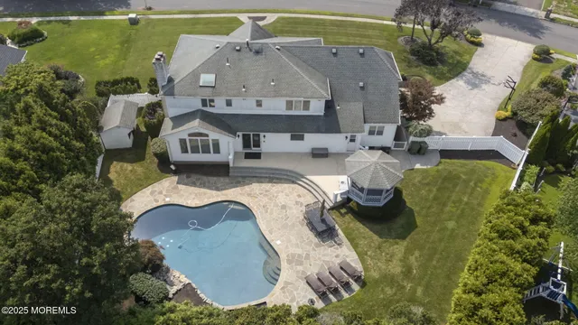 an aerial view of a house with swimming pool and outdoor seating