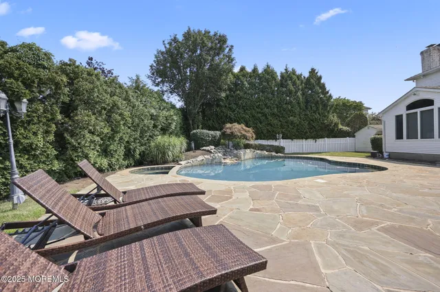 a view of a patio with table and chairs with wooden floor and fence