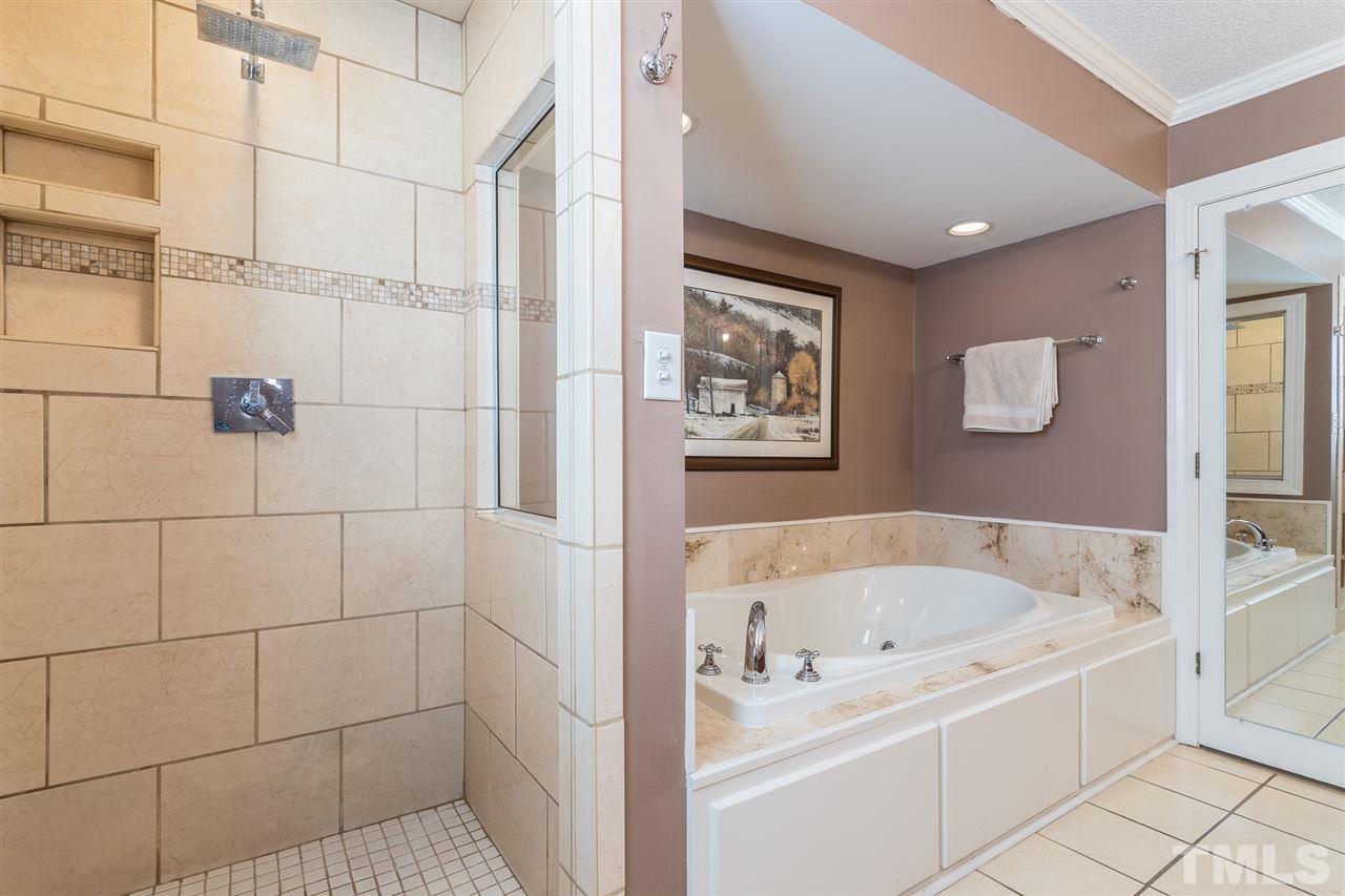 7728 Rainwater Road Raleigh, NC 27615 - Photo 18 of 30 The master shower was enlarged and remodeled with new tile surround, shampoo niche, rain shower head, taller ceiling highet and a wider entry door.