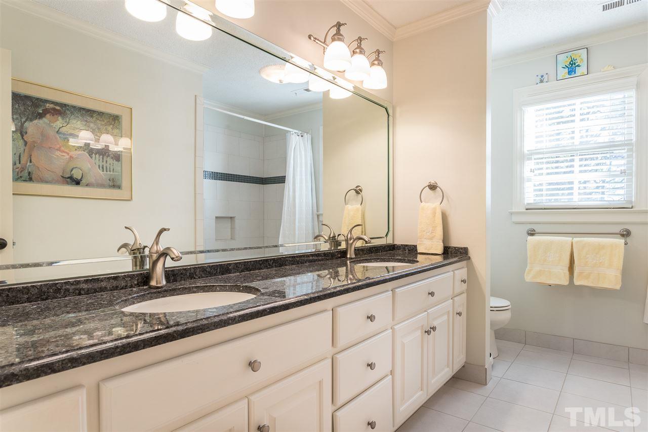 7728 Rainwater Road Raleigh, NC 27615 - Photo 23 of 30 Granite counters, double sinks, updated fixtures, tile flooring, and tub/shower combo with tile surround. This is a very large bathroom!