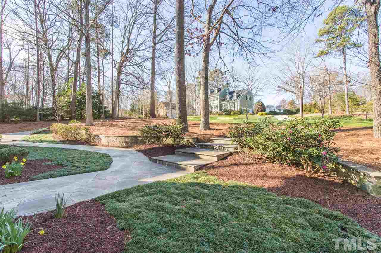 7728 Rainwater Road Raleigh, NC 27615 - Photo 4 of 30 Such magnificent landscaping! What a parklike setting! A beautiful stone wall and a flagstone walkway lead to the front porch.