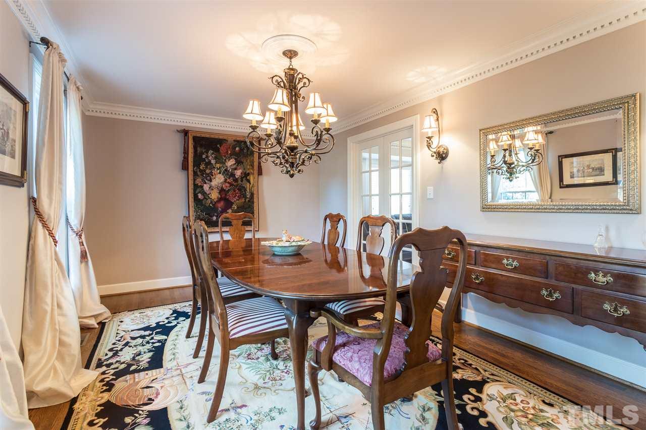 7728 Rainwater Road Raleigh, NC 27615 - Photo 5 of 30 The dining room easily accommodates seating for 8-10 and offers dentil moulding, hardwoods floors, smooth ceilings and double glass French doors that lead to the den/first floor office.