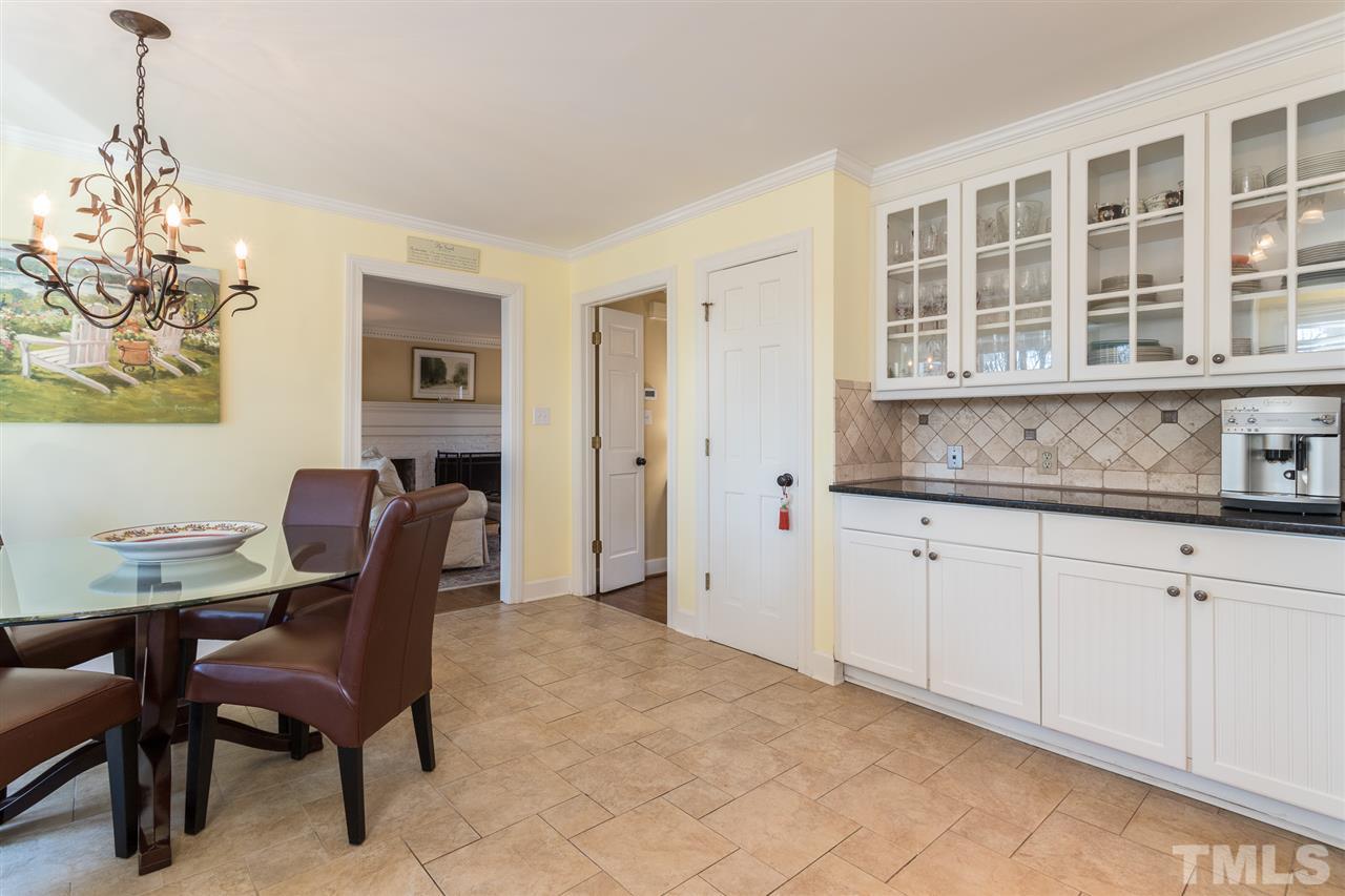 7728 Rainwater Road Raleigh, NC 27615 - Photo 10 of 30 Tile backsplash, abundant counter space, updated lighting, pantry, crown molding, and ceramic tile flooring