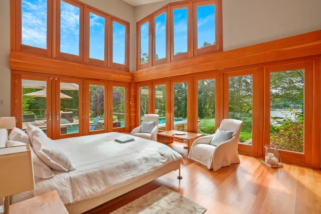 a large bedroom with bed and large windows