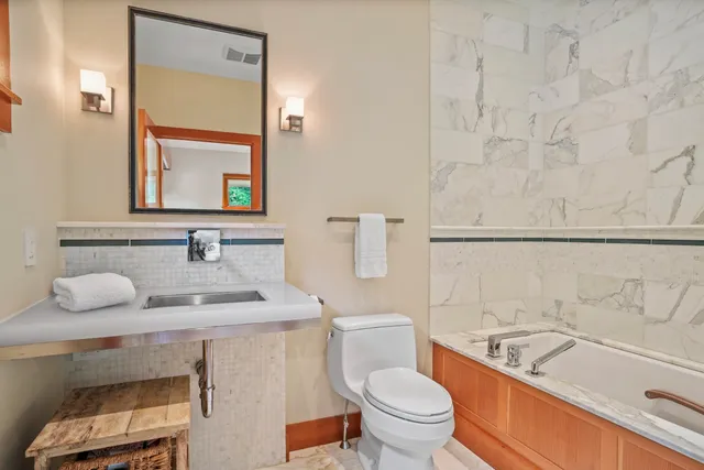 a bathroom with a granite countertop sink mirror vanity and toilet