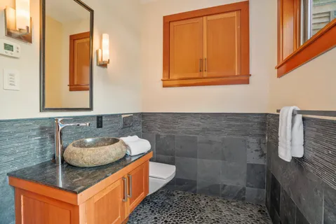 a bathroom with a sink a toilet and mirror