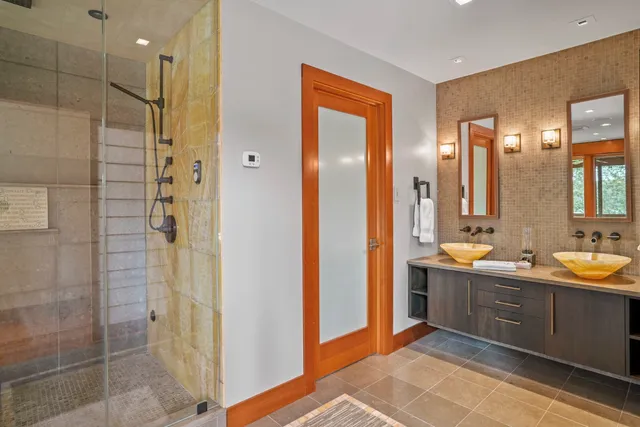 a bathroom with a double vanity sink mirror and shower