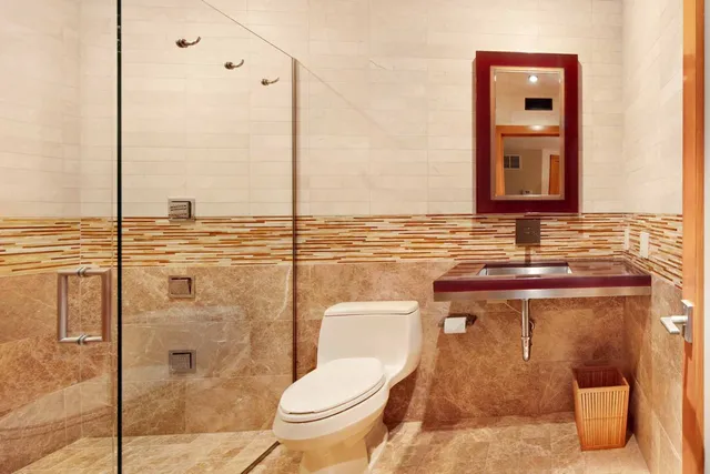 a bathroom with a toilet a sink and mirror