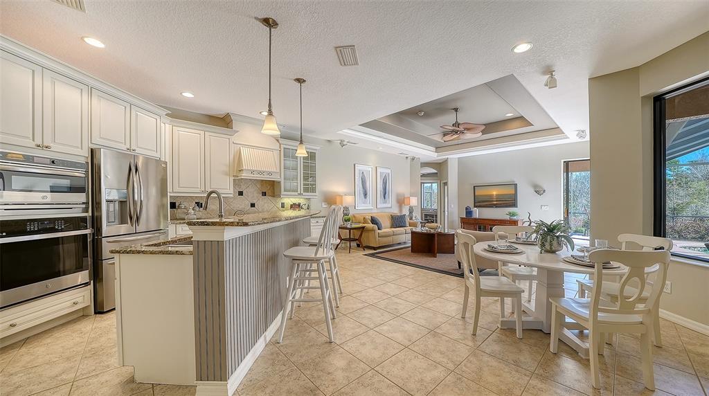 664 Crane Prairie Way Osprey, FL 34229 - Photo 12 of 69 a kitchen with stainless steel appliances kitchen island granite countertop a refrigerator and microwave