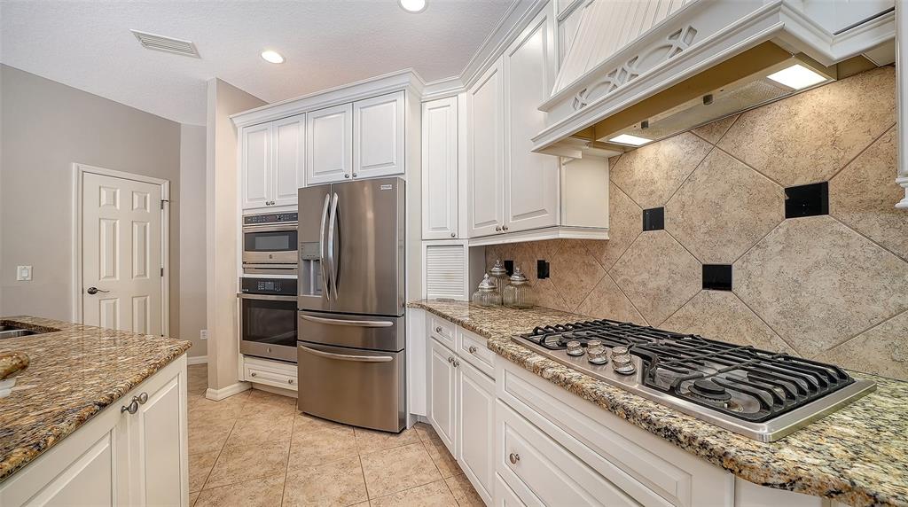 664 Crane Prairie Way Osprey, FL 34229 - Photo 16 of 69 a kitchen with stainless steel appliances granite countertop a stove and a refrigerator