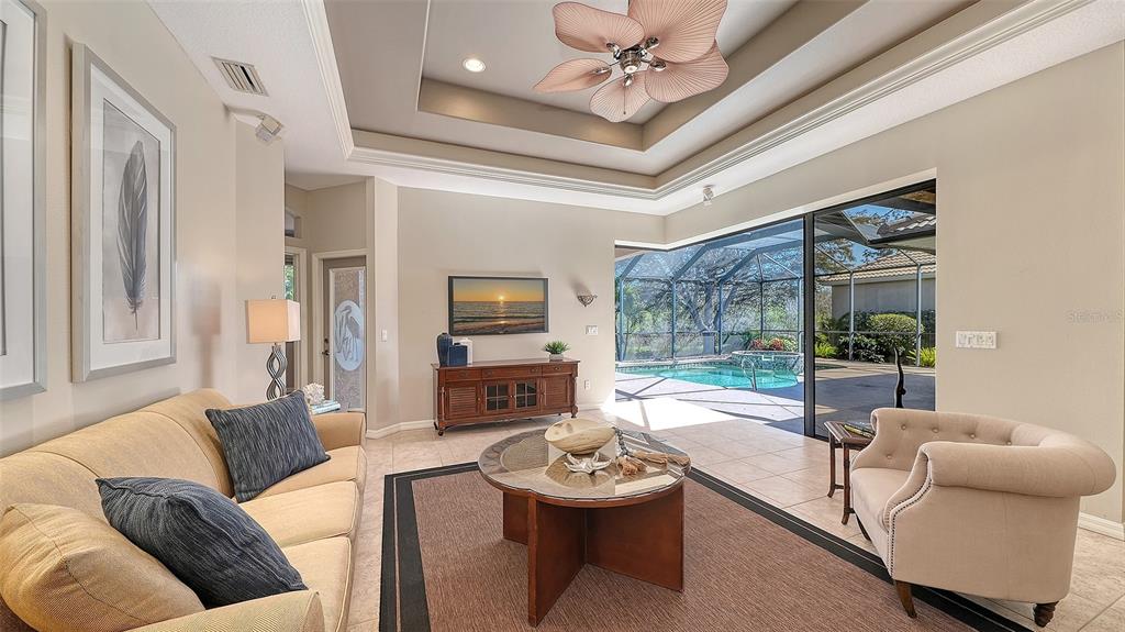 664 Crane Prairie Way Osprey, FL 34229 - Photo 21 of 69 a living room with furniture a fireplace and a chandelier