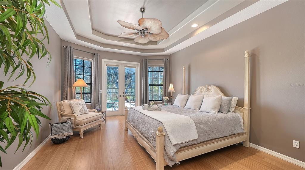 664 Crane Prairie Way Osprey, FL 34229 - Photo 30 of 69 a bedroom with a large bed and a chandelier