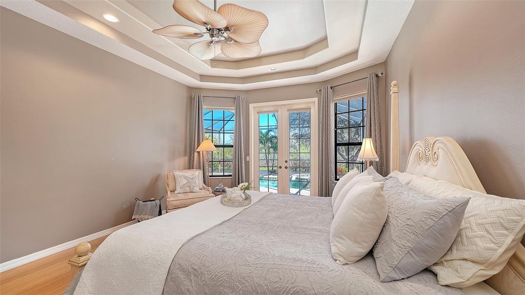 664 Crane Prairie Way Osprey, FL 34229 - Photo 31 of 69 a bedroom with a large bed and a chandelier