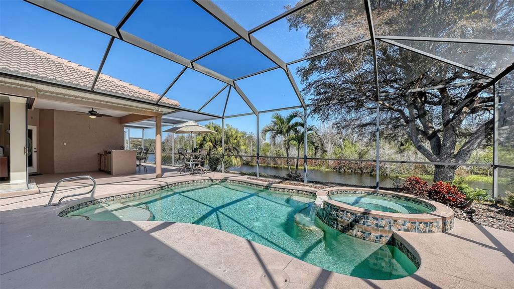 664 Crane Prairie Way Osprey, FL 34229 - Photo 46 of 69 a patio with a table and chairs under an umbrella