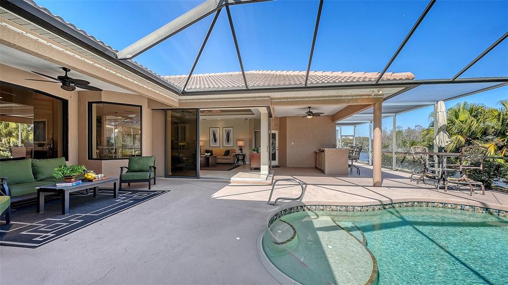 664 Crane Prairie Way Osprey, FL 34229 - Photo 49 of 69 a view of a patio with table and chairs under an umbrella