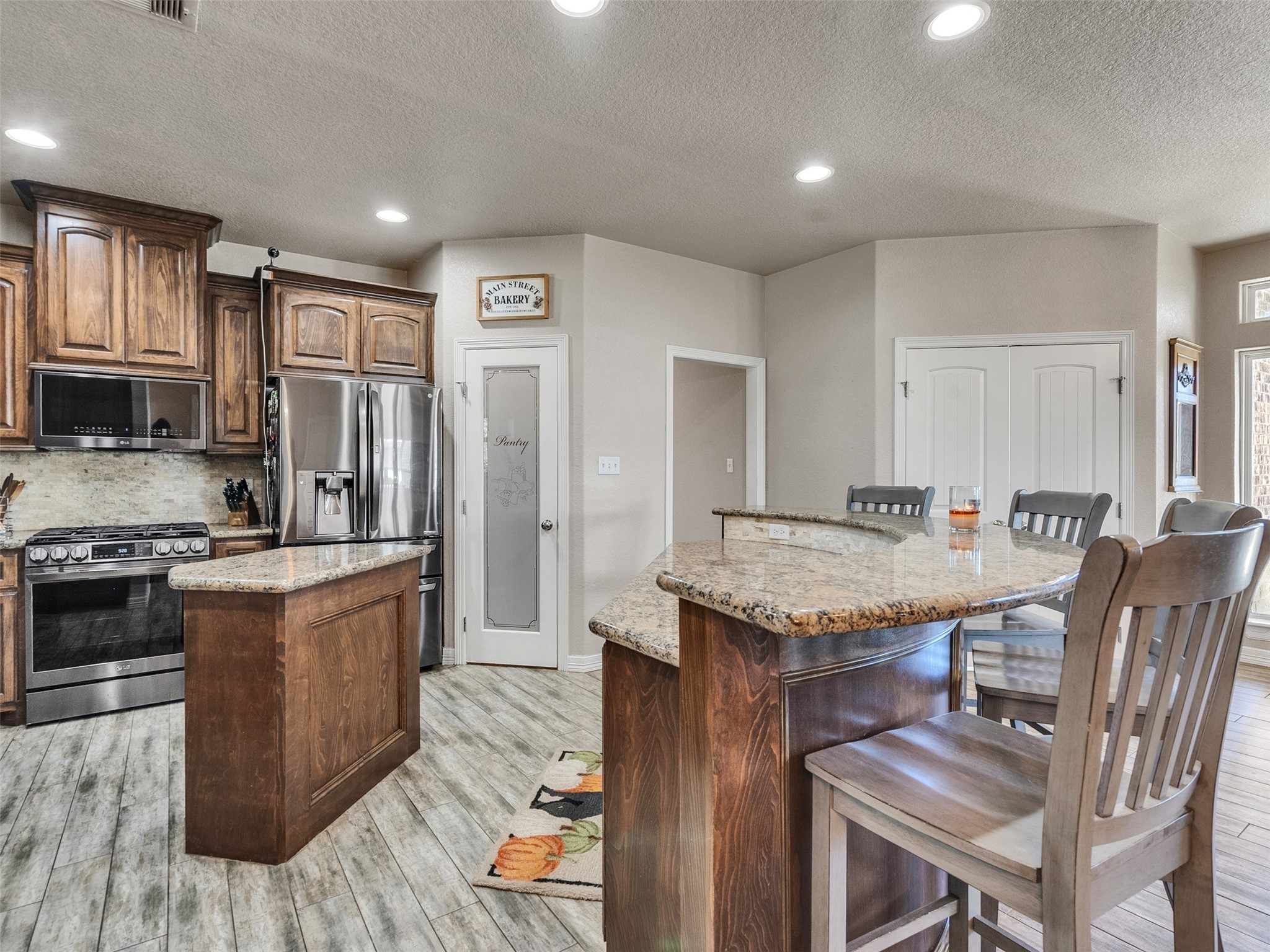 155 Horse Shoe Trail Angleton, TX 77515 - Photo 6 of 29 a open kitchen with stainless steel appliances granite countertop a stove top oven a sink dishwasher and a refrigerator with wooden floor