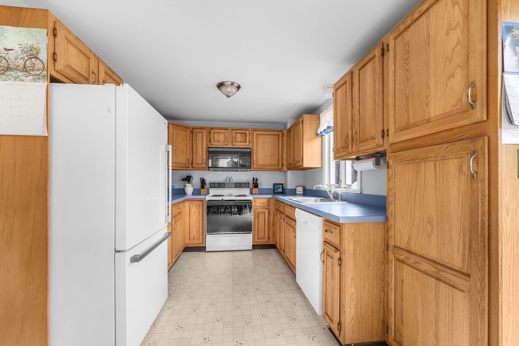 38 High Street, Unit 8 Hanson, MA 02341 - Photo 13 of 37 a kitchen with stainless steel appliances granite countertop a refrigerator a stove a sink dishwasher and wooden cabinets with wooden floor