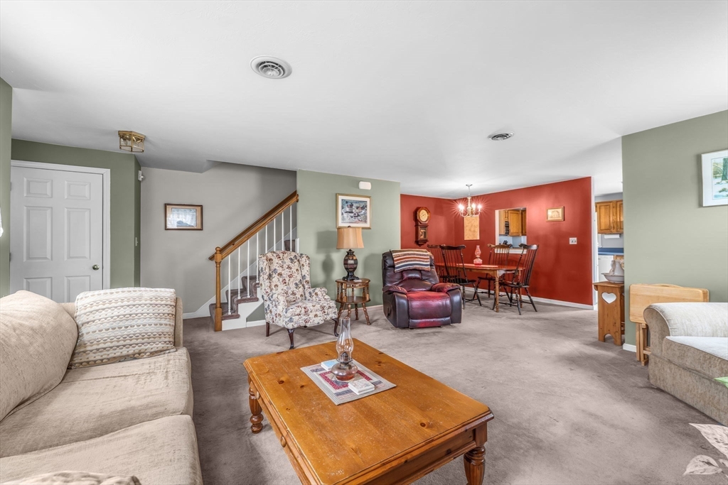 38 High Street, Unit 8 Hanson, MA 02341 - Photo 9 of 37 a living room with furniture a rug and a chandelier