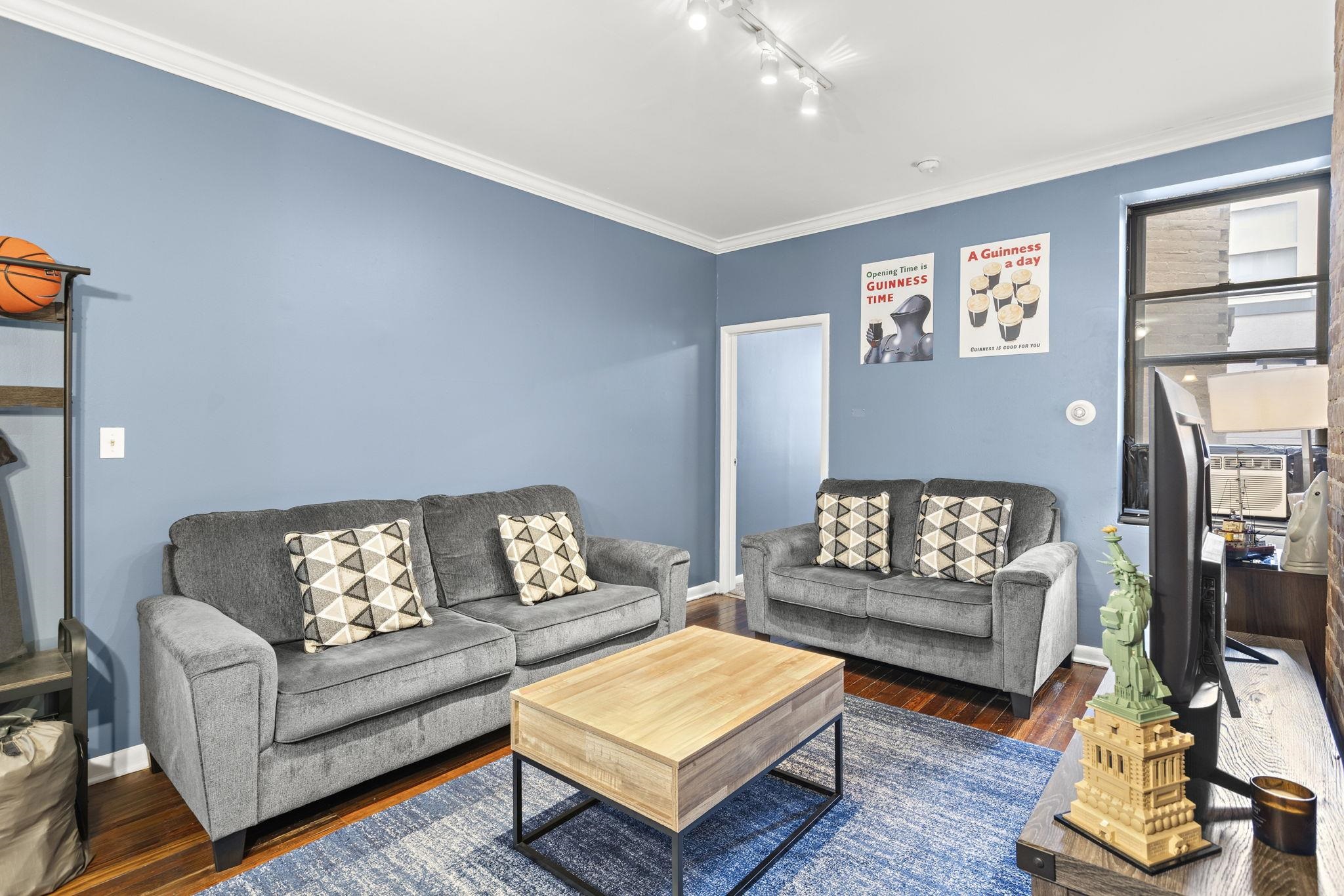 263 1st Street, Unit 4R Hoboken, NJ 07030 - Photo 2 of 11 a living room with furniture and a flat screen tv