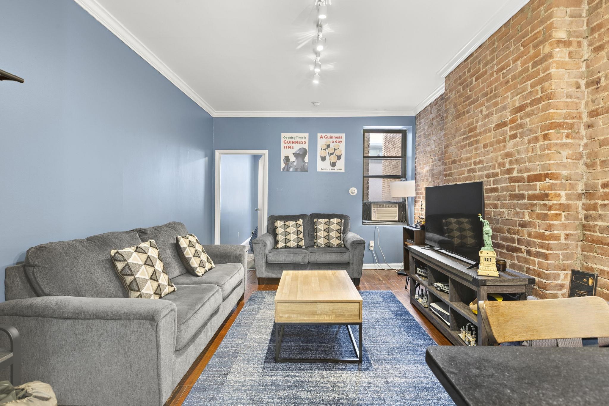 263 1st Street, Unit 4R Hoboken, NJ 07030 - Photo 3 of 11 a living room with furniture and a flat screen tv