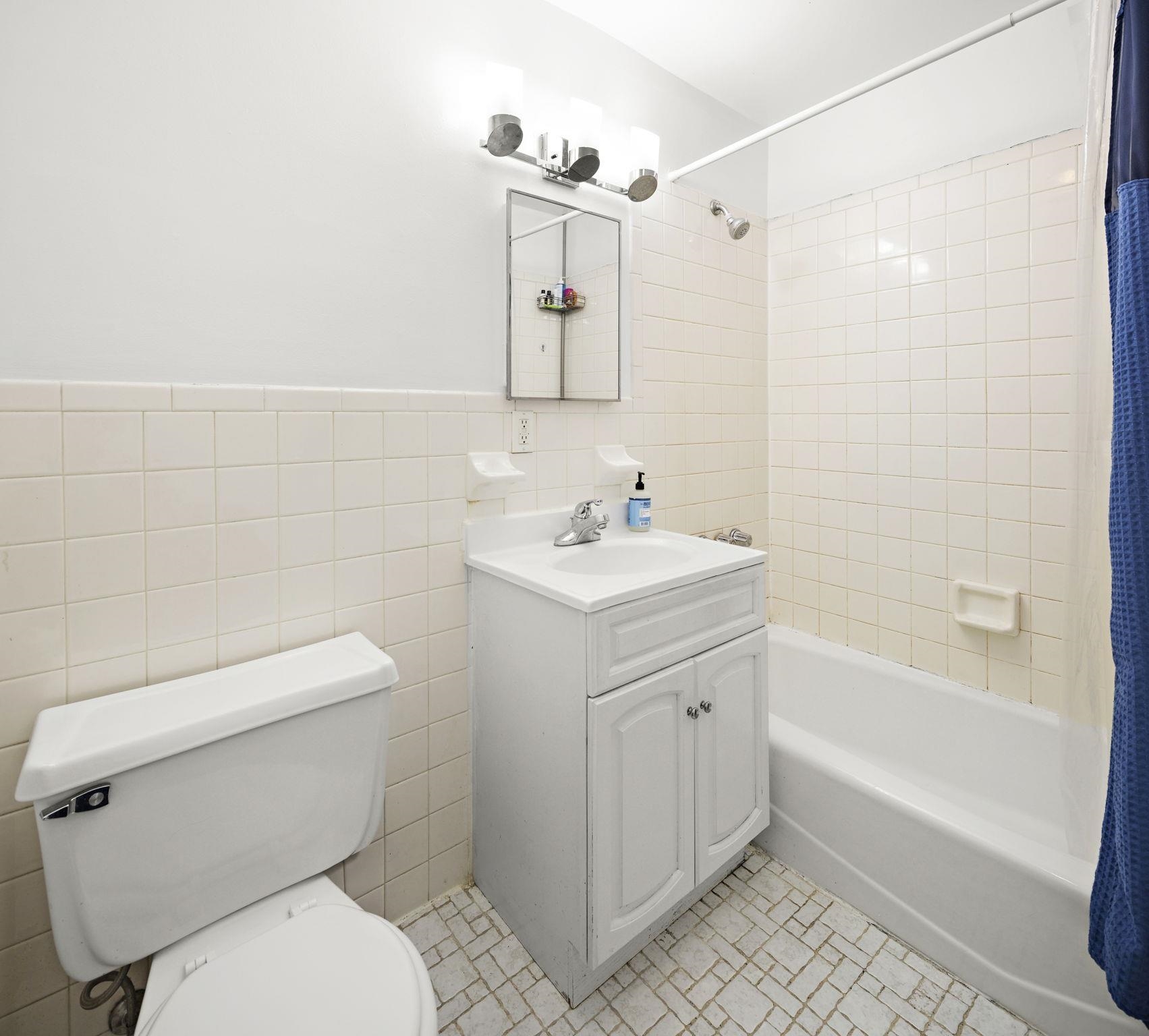 263 1st Street, Unit 4R Hoboken, NJ 07030 - Photo 8 of 11 a bathroom with a sink a toilet and shower