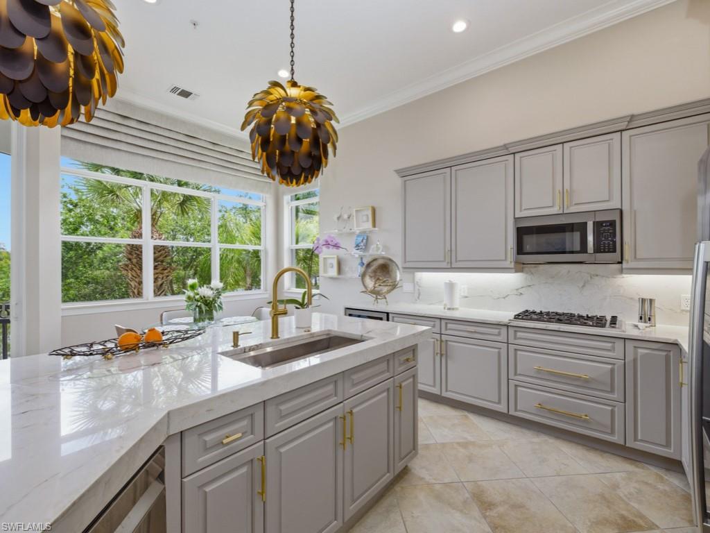 28511 Calabria Court, Unit 202 Naples, FL 34110 - Photo 11 of 44 a kitchen with stainless steel appliances a sink a stove and a microwave