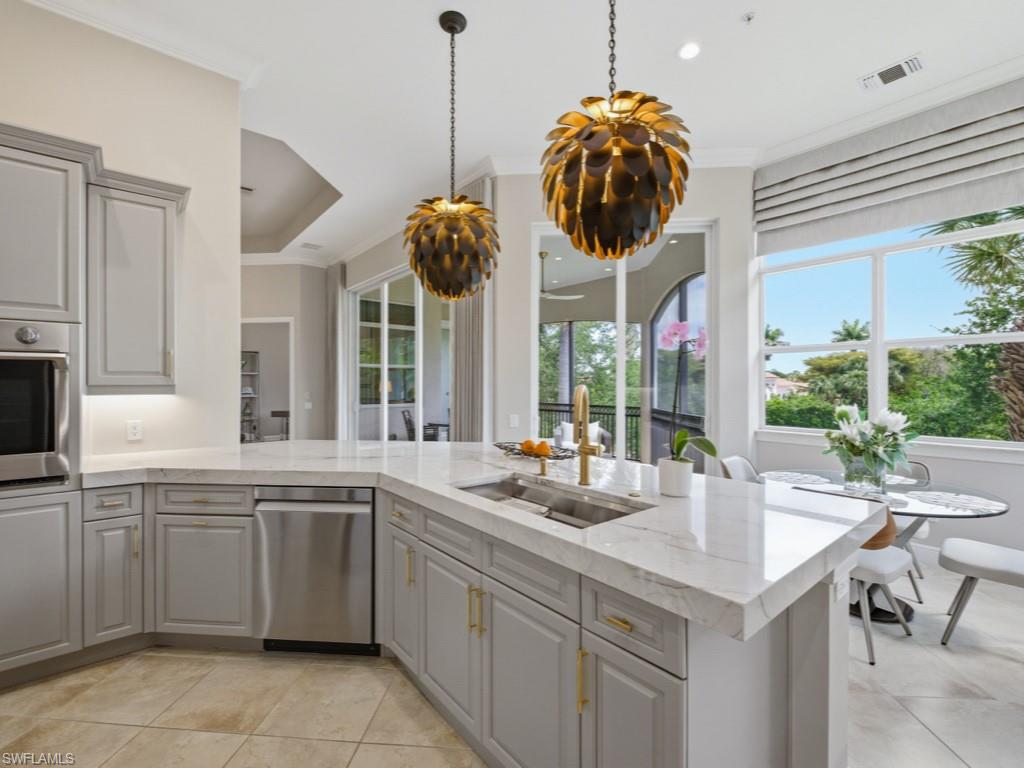 28511 Calabria Court, Unit 202 Naples, FL 34110 - Photo 12 of 44 a kitchen with a sink and dishwasher with white cabinets