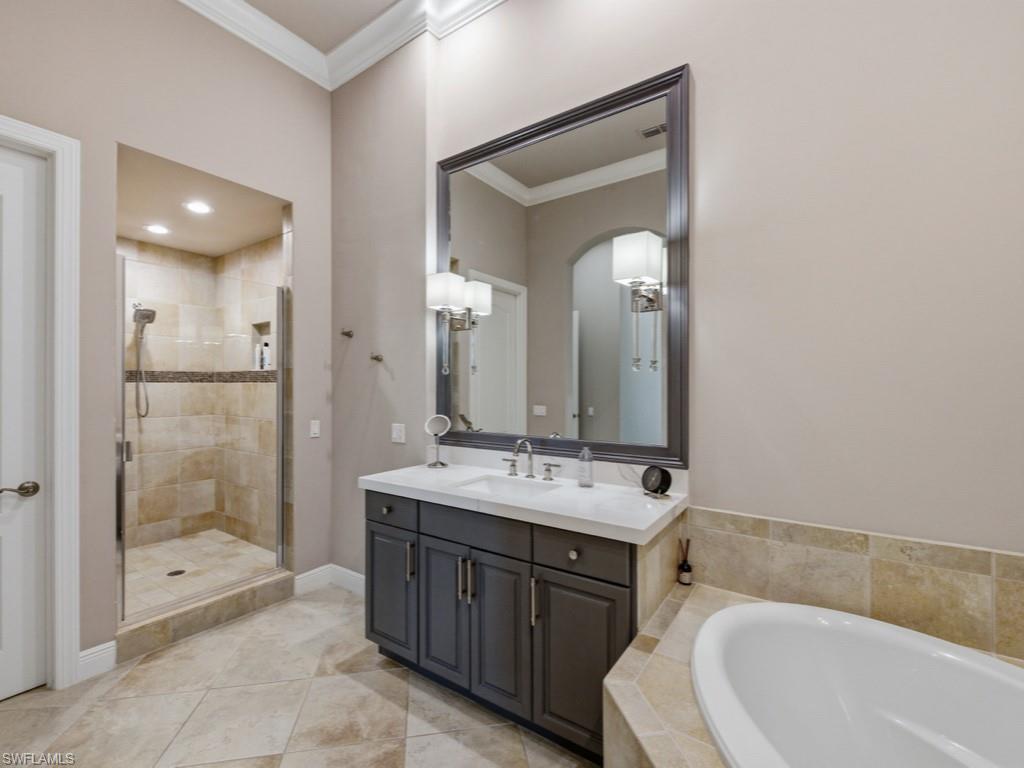 28511 Calabria Court, Unit 202 Naples, FL 34110 - Photo 16 of 44 a bathroom with a tub sink mirror and shower