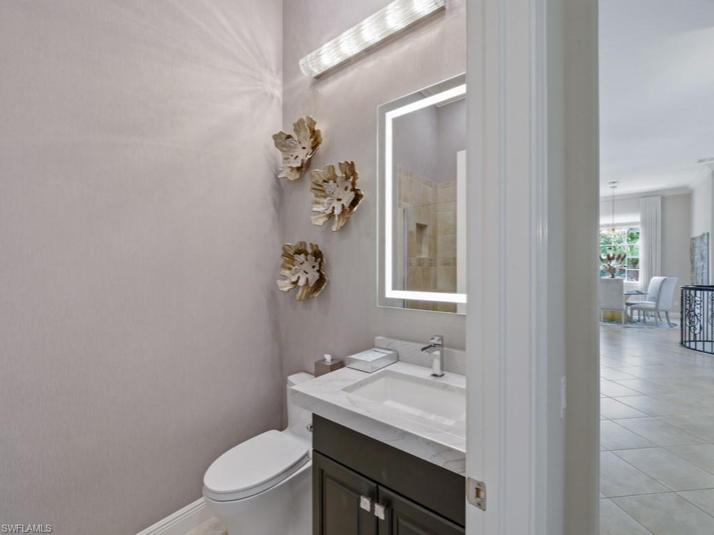 28511 Calabria Court, Unit 202 Naples, FL 34110 - Photo 21 of 44 a bathroom with a granite countertop sink a toilet and mirror