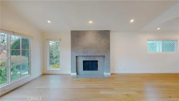 a view of an empty room with a fireplace and a window