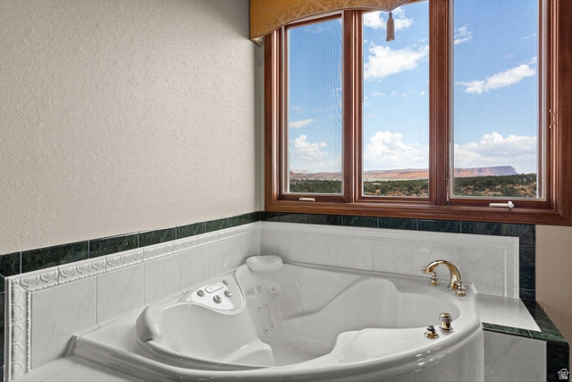 5615 East Eight Mile Gap Road Kanab, UT 84741 - Photo 21 of 81 Bathroom with a textured wall, a bath, and healthy amount of natural light