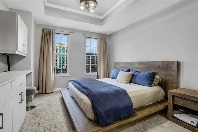 a bedroom with a bed a mirror and a window