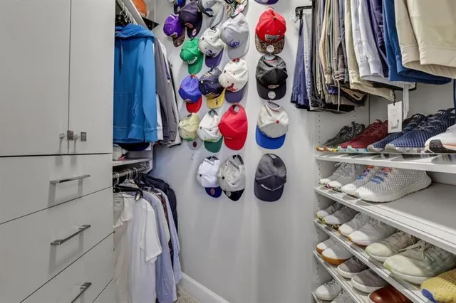 a view of walk in closet with clothes and shoes