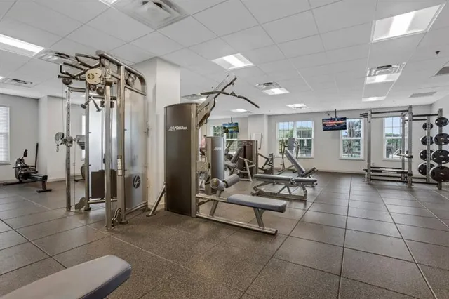 a gym room with lots of furniture and mirrors