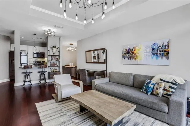 a living room with furniture kitchen view and a chandelier
