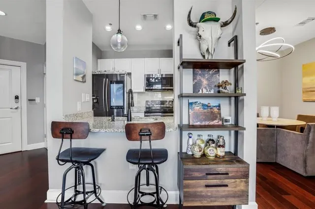 a kitchen with stainless steel appliances granite countertop a table and chairs in it