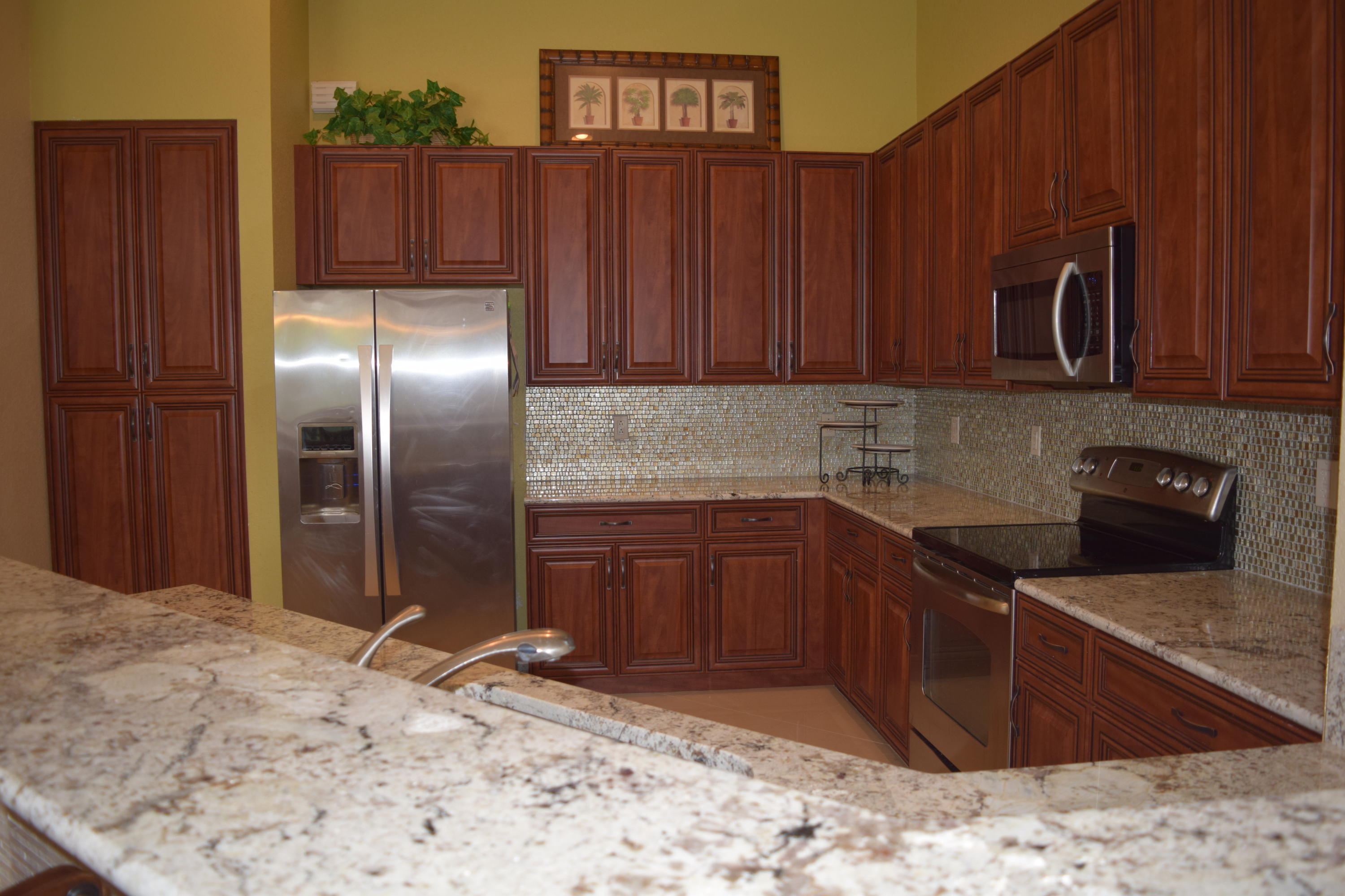 132 Via Isabela Jupiter, FL 33458 - Photo 8 of 27 a kitchen with stainless steel appliances granite countertop a refrigerator and a sink