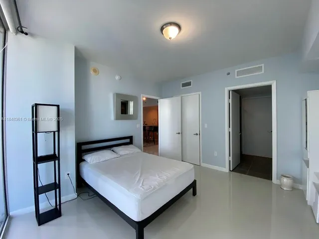 a bedroom with a bed and cabinet