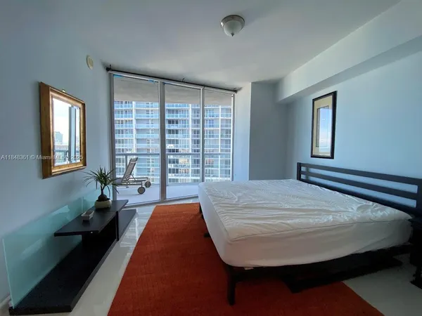 a bed sitting in a bedroom next to a window