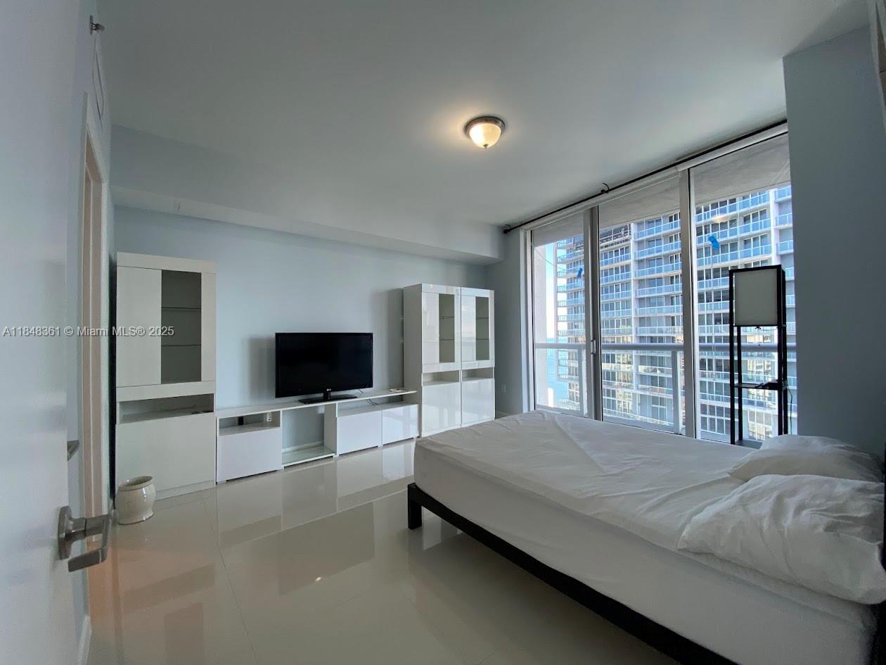 475 Brickell Avenue, Unit 4409 Miami, FL 33131 - Photo 6 of 37 a bedroom with a large bed and a flat tv screen on dresser
