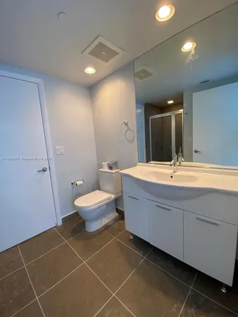 a bathroom with a double vanity sink mirror and toilet