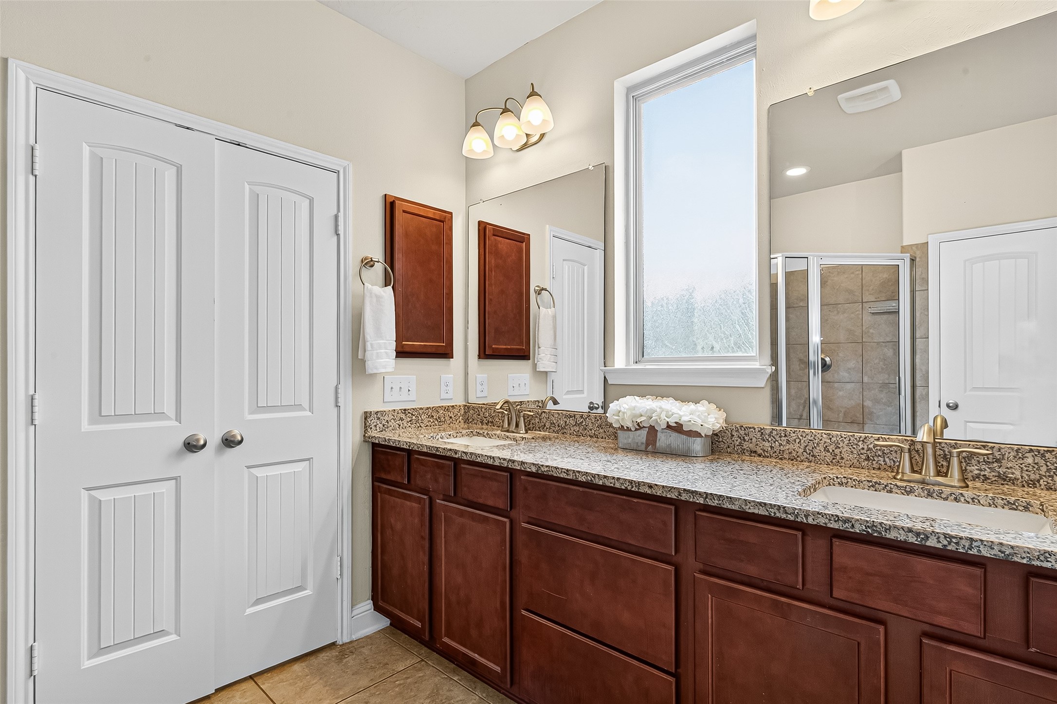 8107 Lockridge Terrace Lane Cypress, TX 77433 - Photo 33 of 50 Final view of the primary bathroom reveals the spacious dual-sink vanity, abundant cabinet storage, and beautiful granite counters—ideal for busy mornings or relaxed evenings. The frosted window provides both natural light and privacy, adding to the spa-like feel of this retreat.