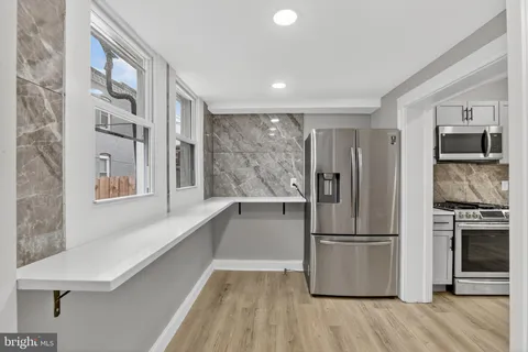 a kitchen with stainless steel appliances a refrigerator and a stove top oven