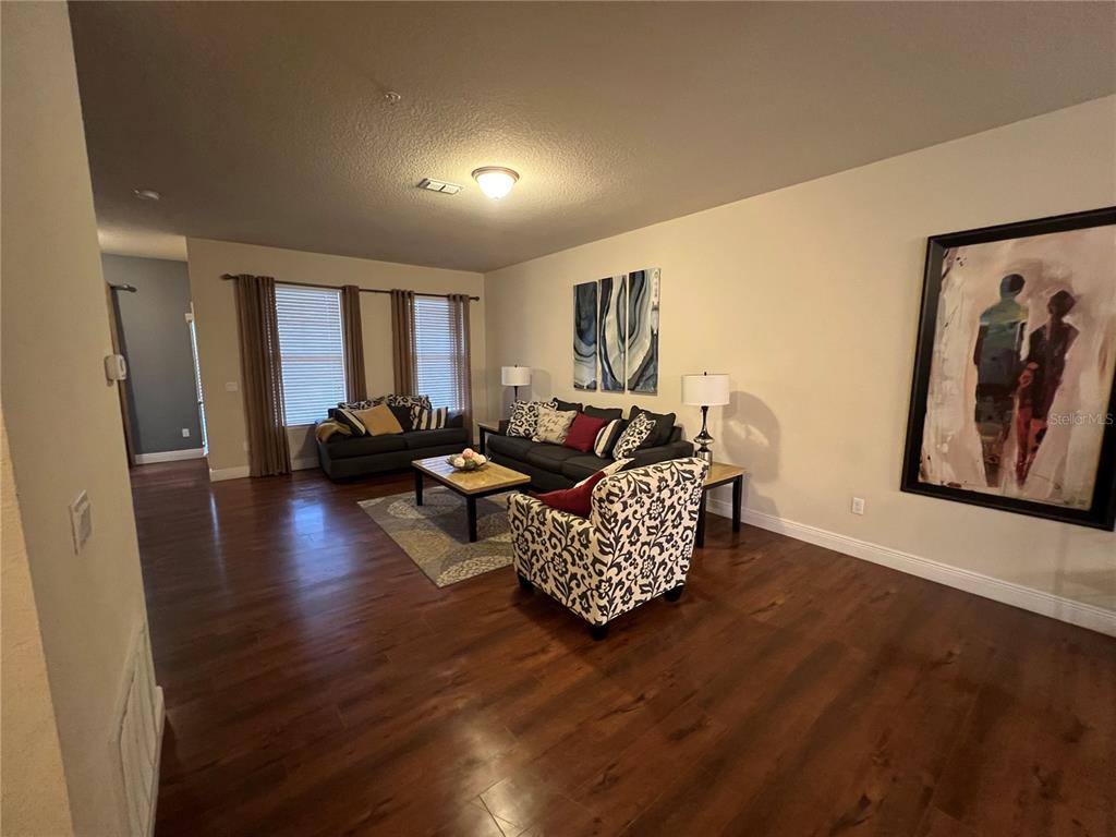10742 Sunset Ridge Lane Orlando, FL 32832 - Photo 12 of 40 a living room with furniture and a wooden floor
