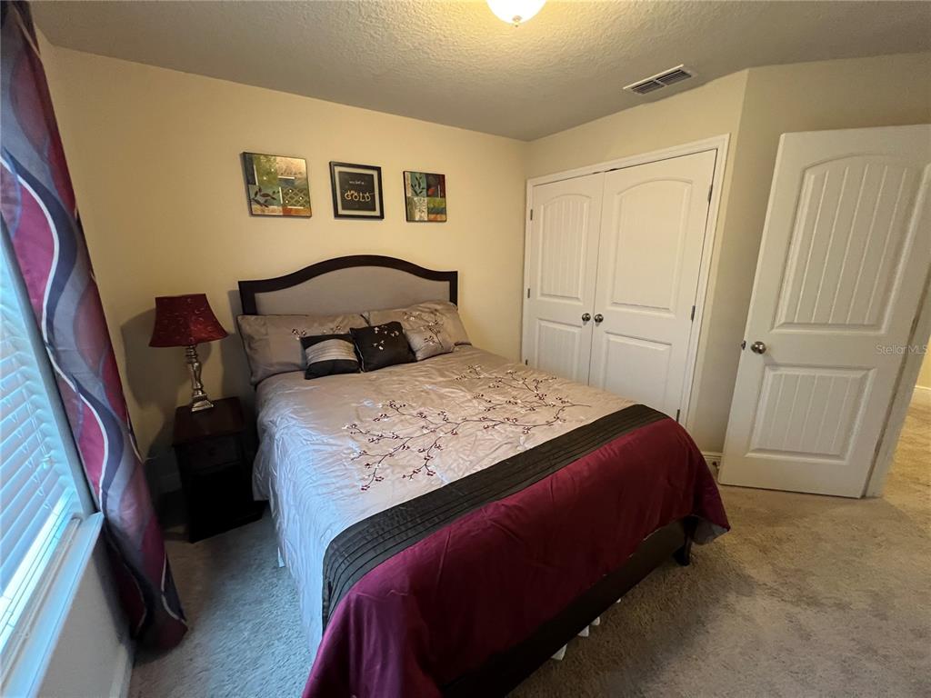 10742 Sunset Ridge Lane Orlando, FL 32832 - Photo 16 of 40 a bedroom with a bed and a mirror