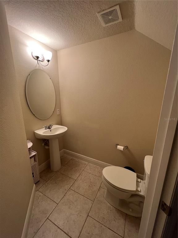10742 Sunset Ridge Lane Orlando, FL 32832 - Photo 22 of 40 a bathroom with a toilet a sink and mirror